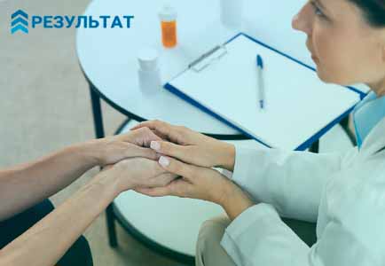 Врач успокаивает пациента держа его за руки